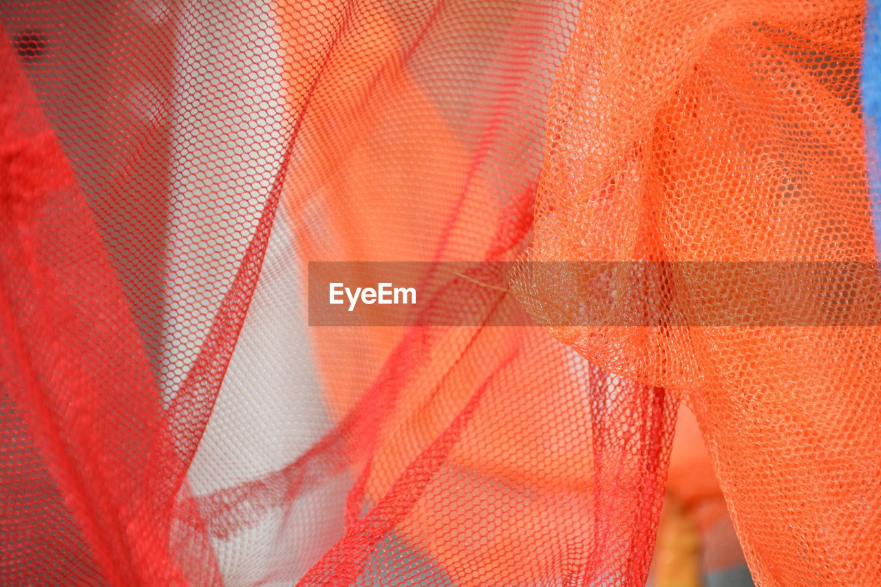 Full frame shot of orange and red fishing net