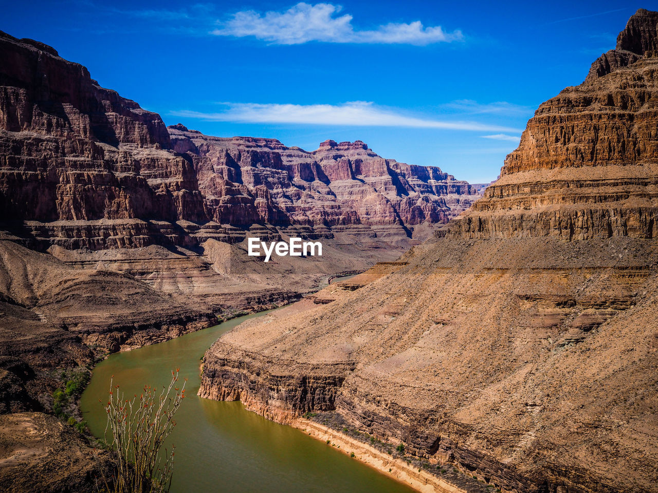 Rocky mountains against cloudy sky on sunny day at grand canyon national park