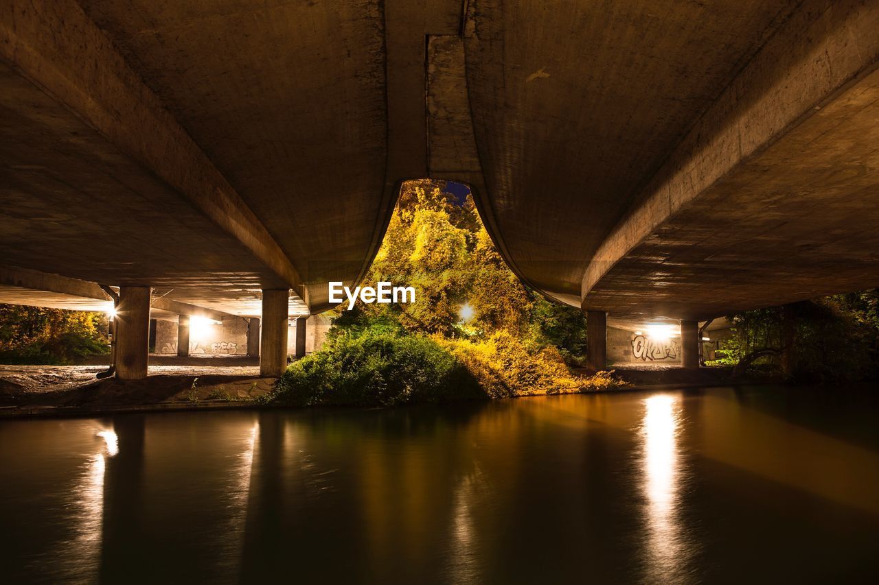 Illuminated bridge over river at night