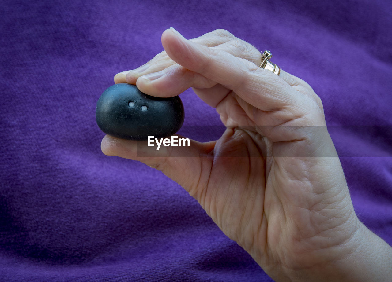 Close-up of hand holding a squash ball