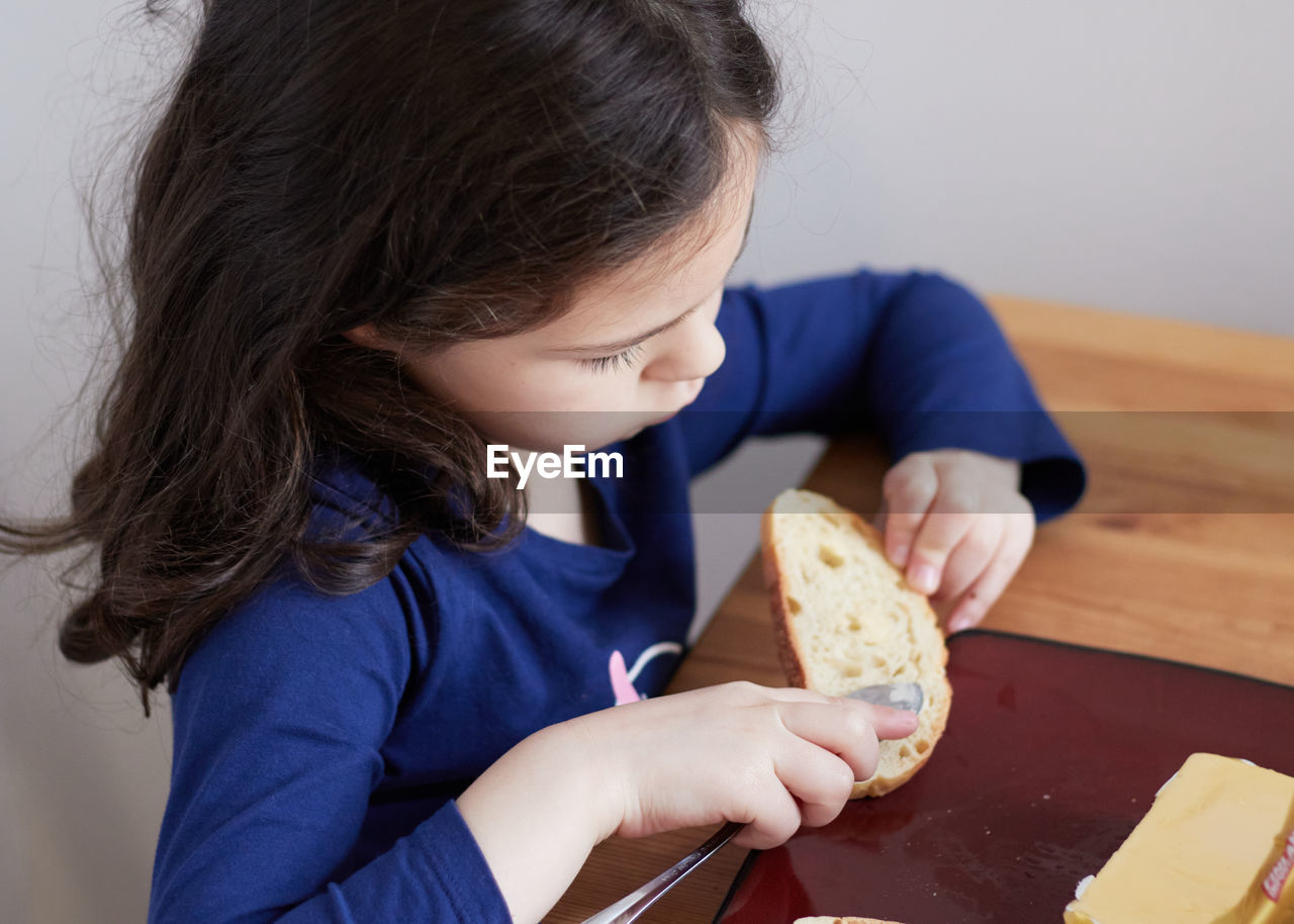 Young girl having snacks at home