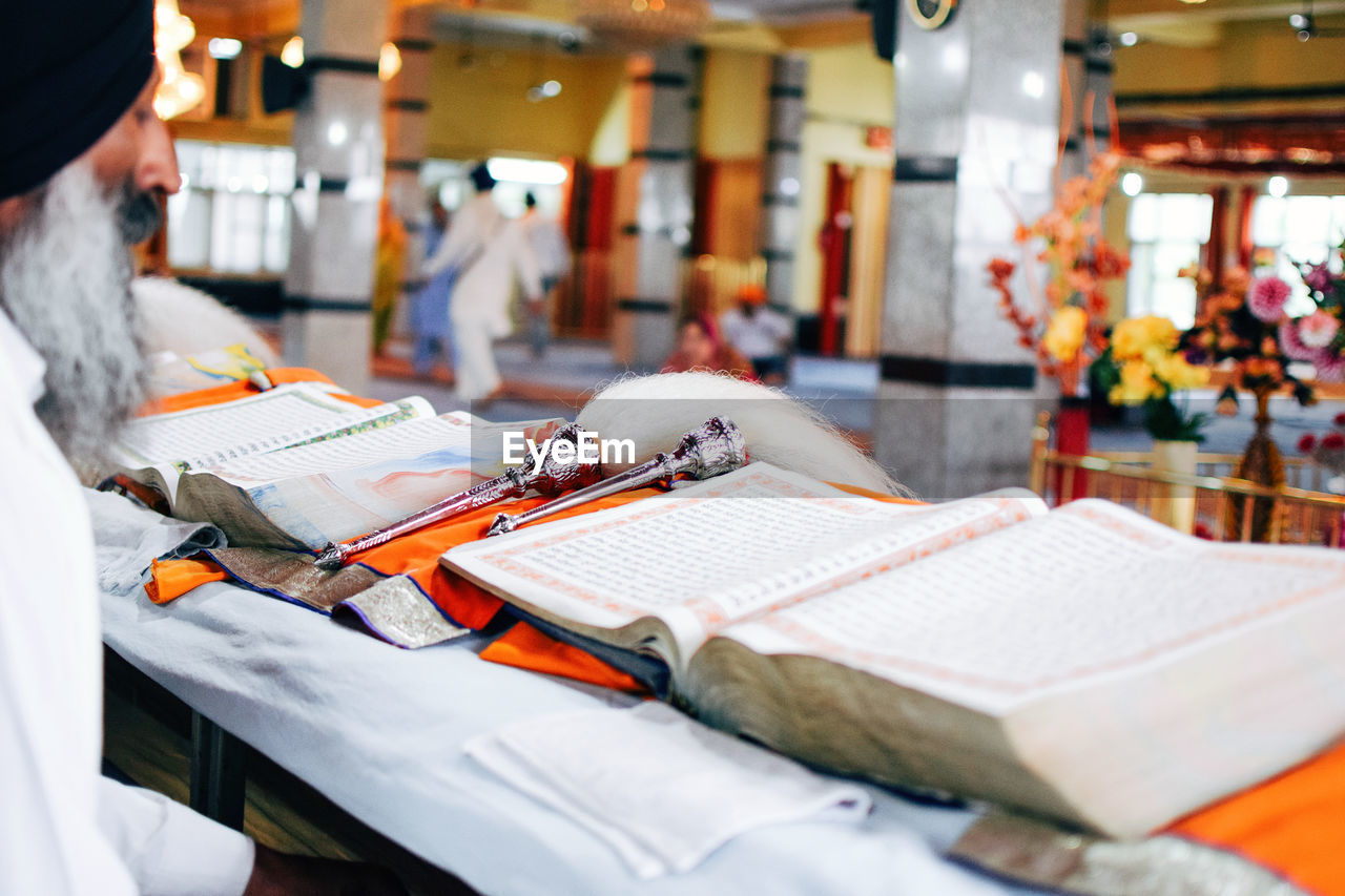 Close-up of man reading book while sitting in temple