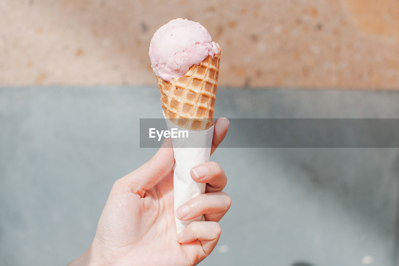 Cropped image of ice cream cone in hand