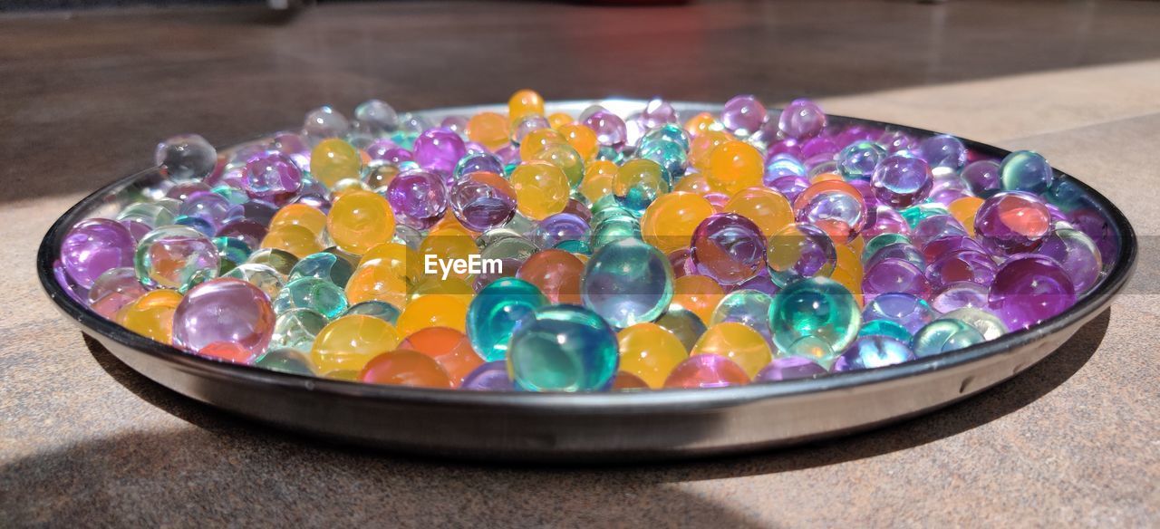 HIGH ANGLE VIEW OF MULTI COLORED CANDIES IN BOWL