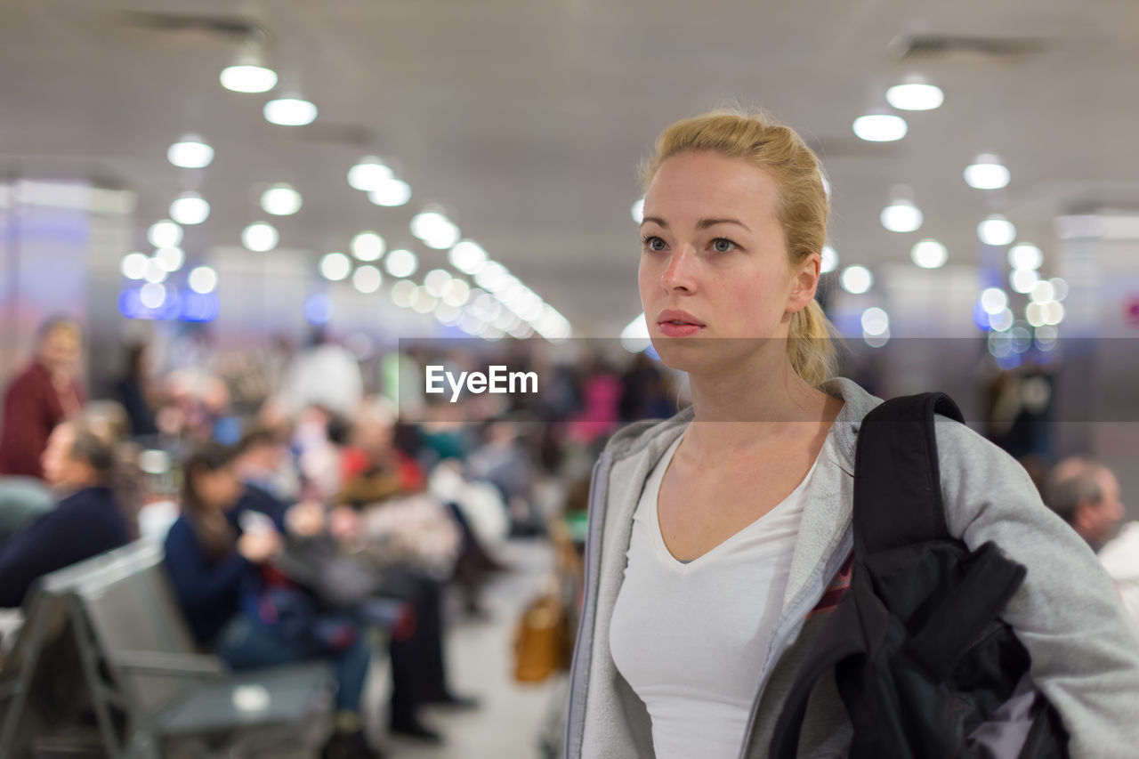Beautiful woman looking away while standing at airport