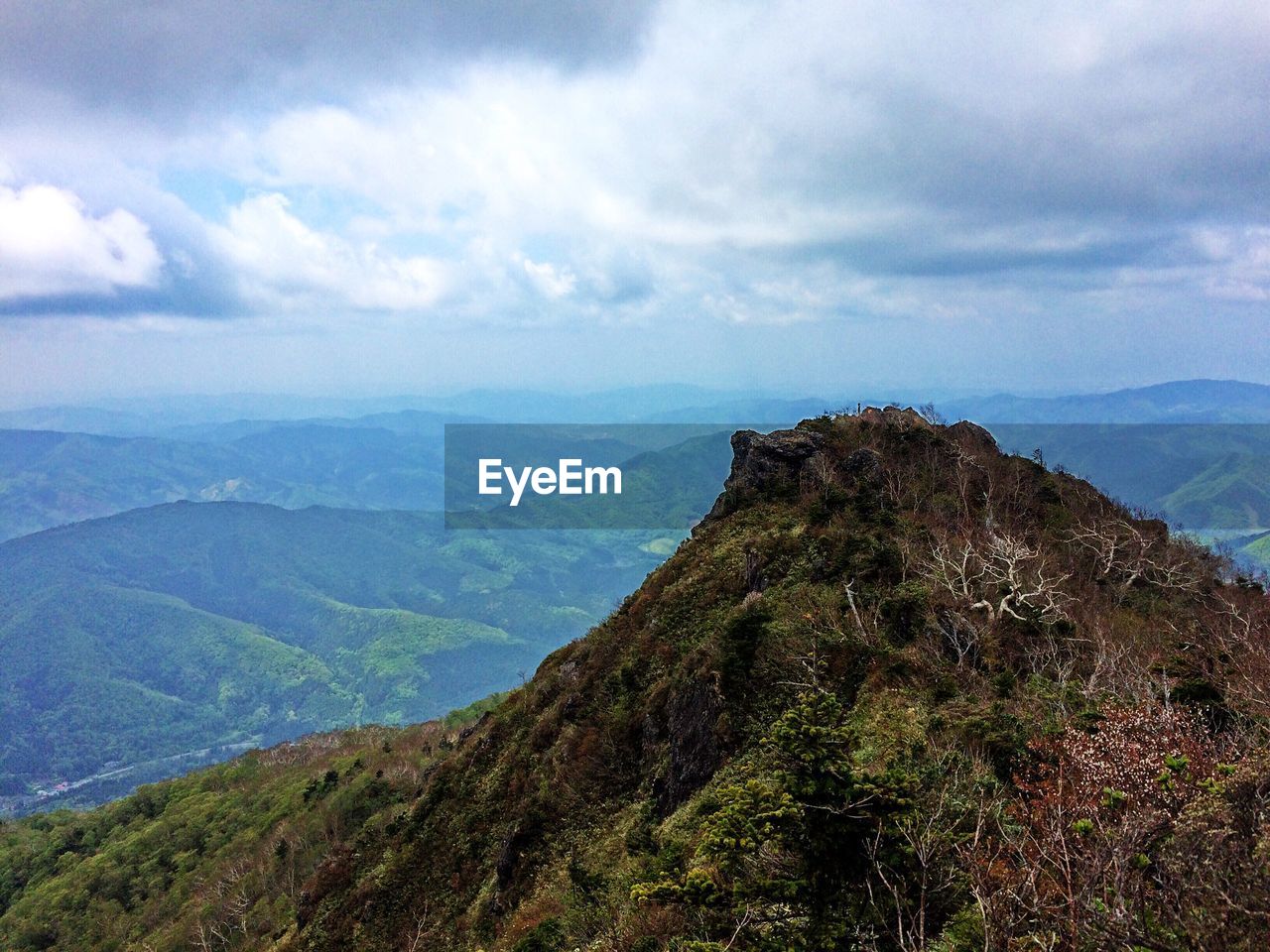 Scenic view of mountains against cloudy sky