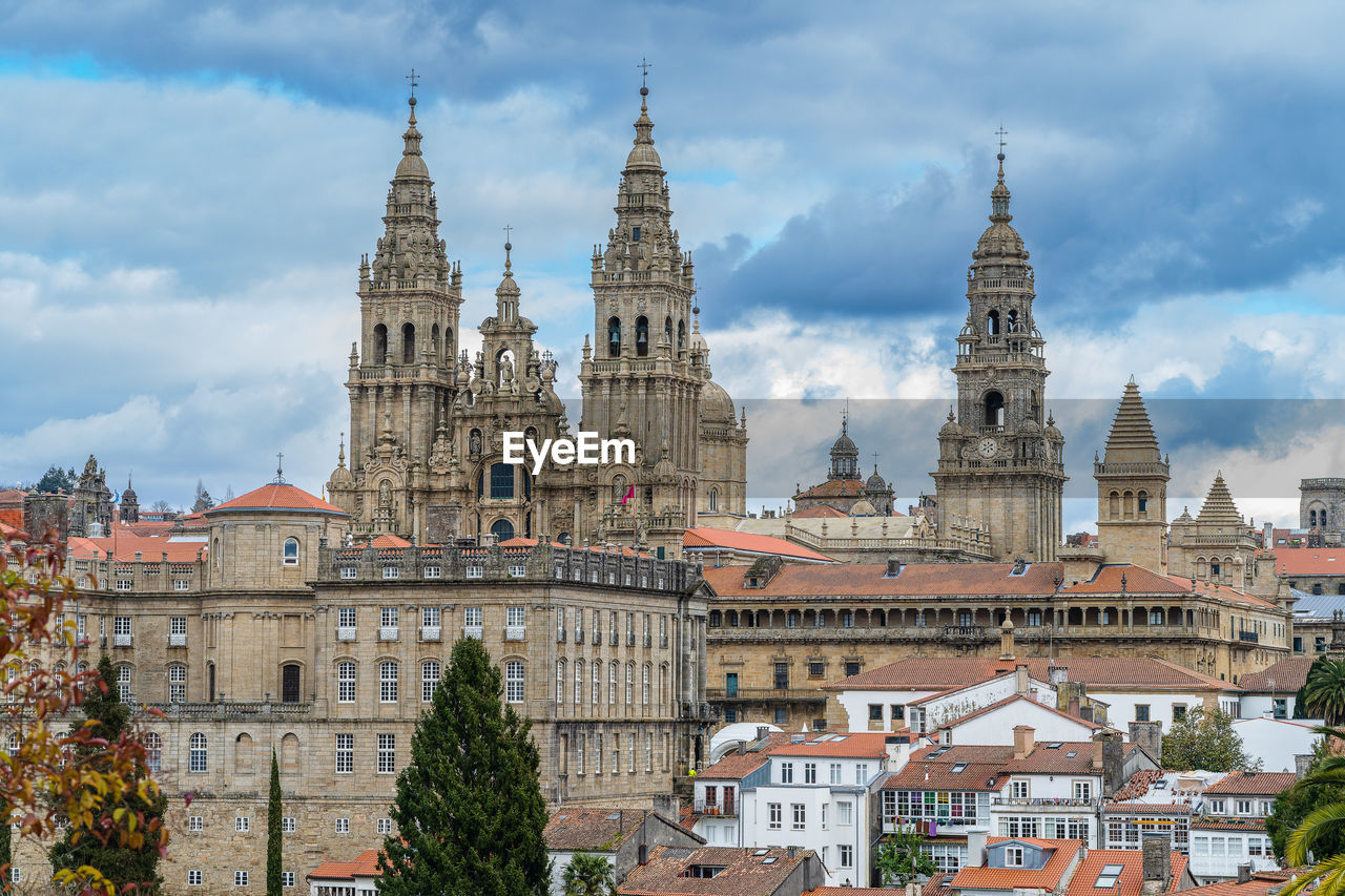 buildings in city against cloudy sky