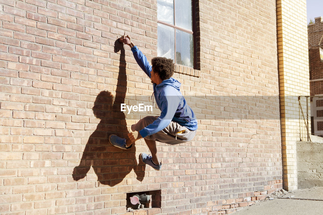 Man climbing brick wall