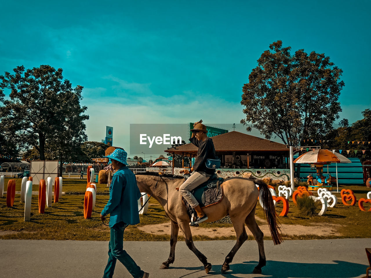 Woman riding horse at farm against sky