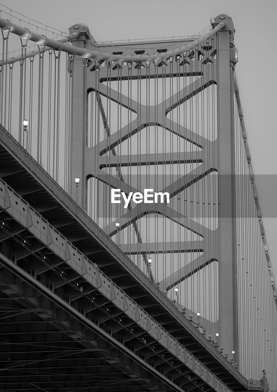 Low angle view of suspension bridge against sky