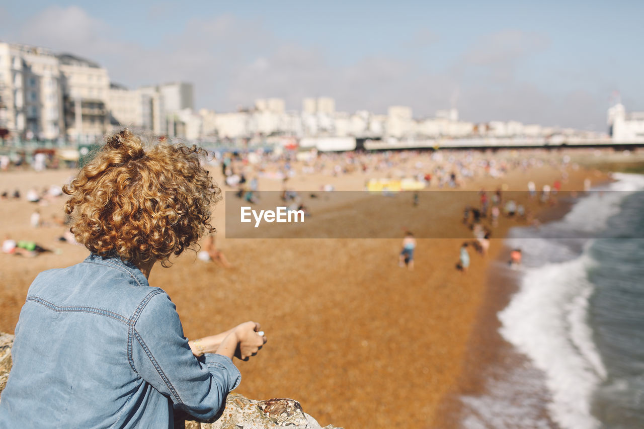 Rear view of woman at brighton pier against sky