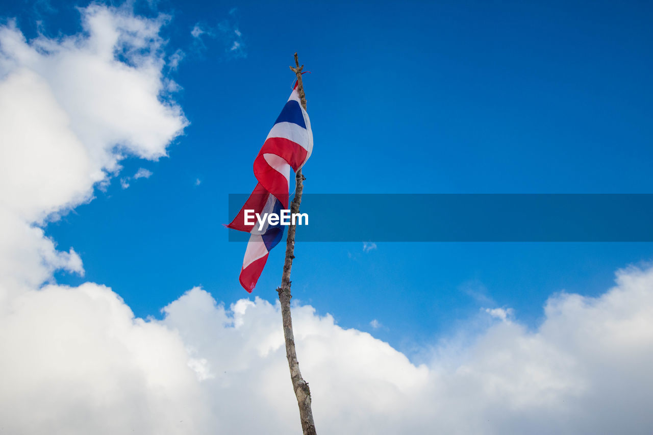 Low angle view of thai flag against blue sky