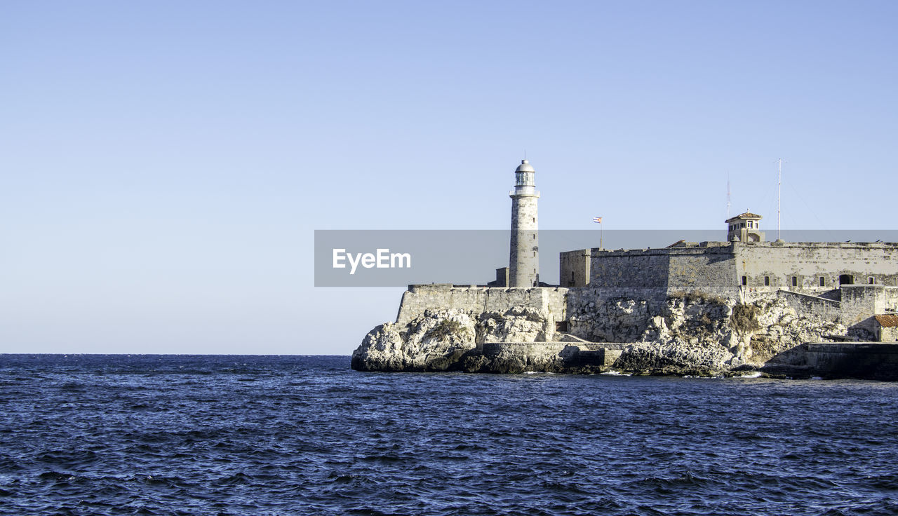 Morro castle by sea against clear sky