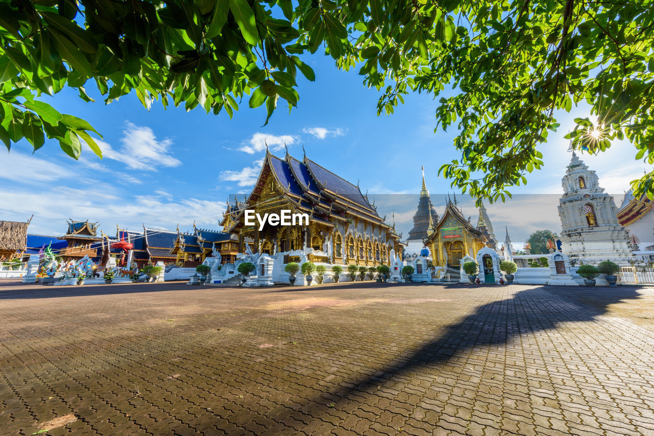 PANORAMIC SHOT OF BUILDINGS AND TREES AGAINST SKY