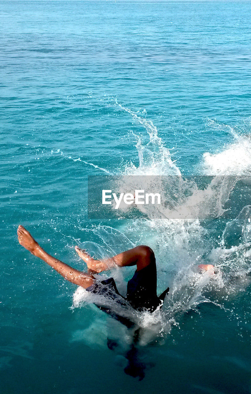 High angle view of man jumping in sea