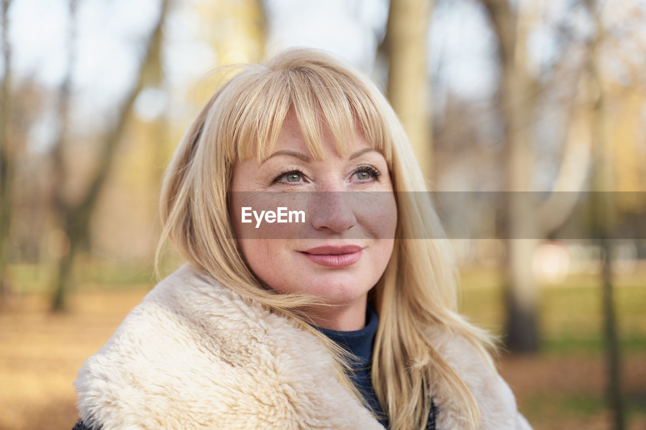 PORTRAIT OF YOUNG WOMAN SMILING OUTDOORS