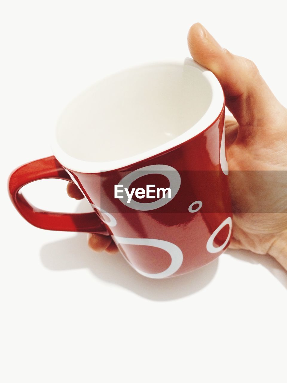 Cropped image of man holding red coffee mug over white background