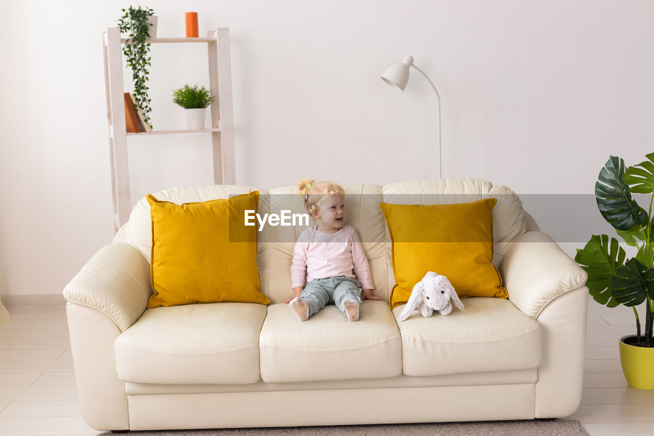 Girl sitting on sofa at home