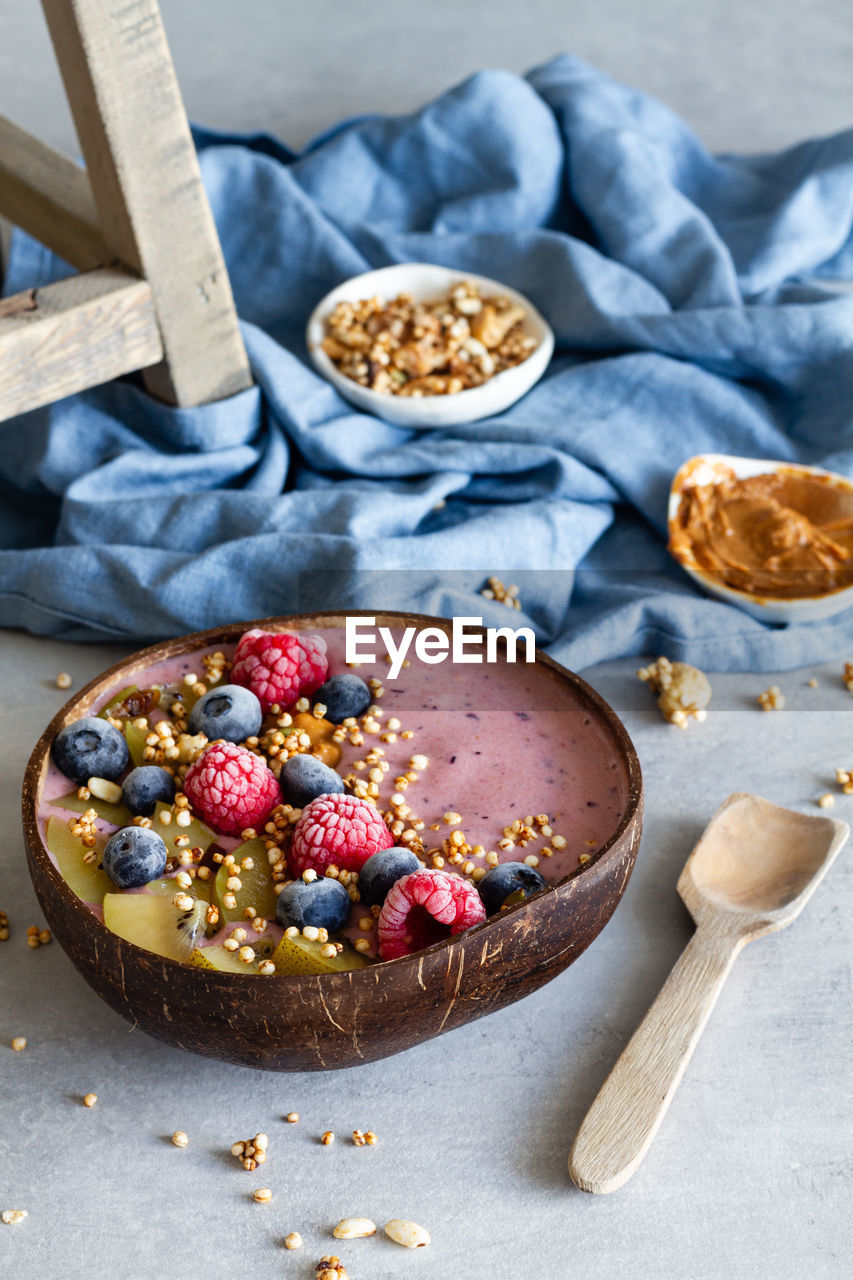 Top view of nutritious breakfast bowl with berries and yogurt served on table in morning