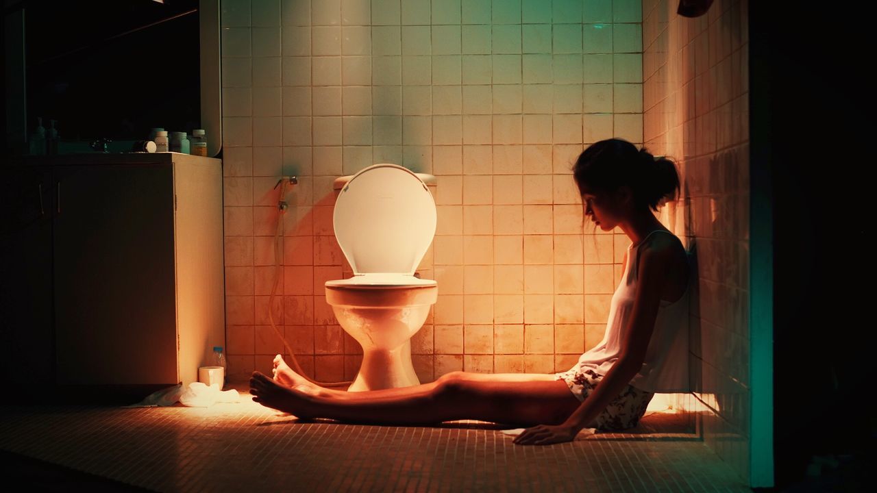 SIDE VIEW OF WOMAN SITTING IN BATHTUB