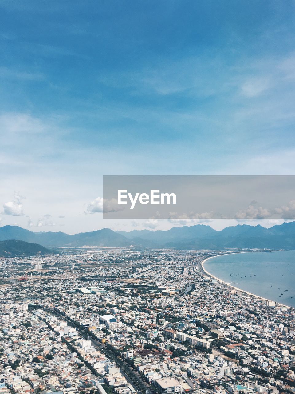 Aerial view of city against cloudy sky