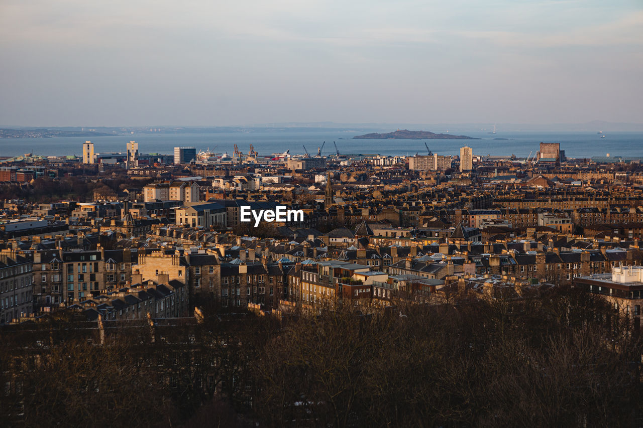 High angle view of townscape by sea against sky