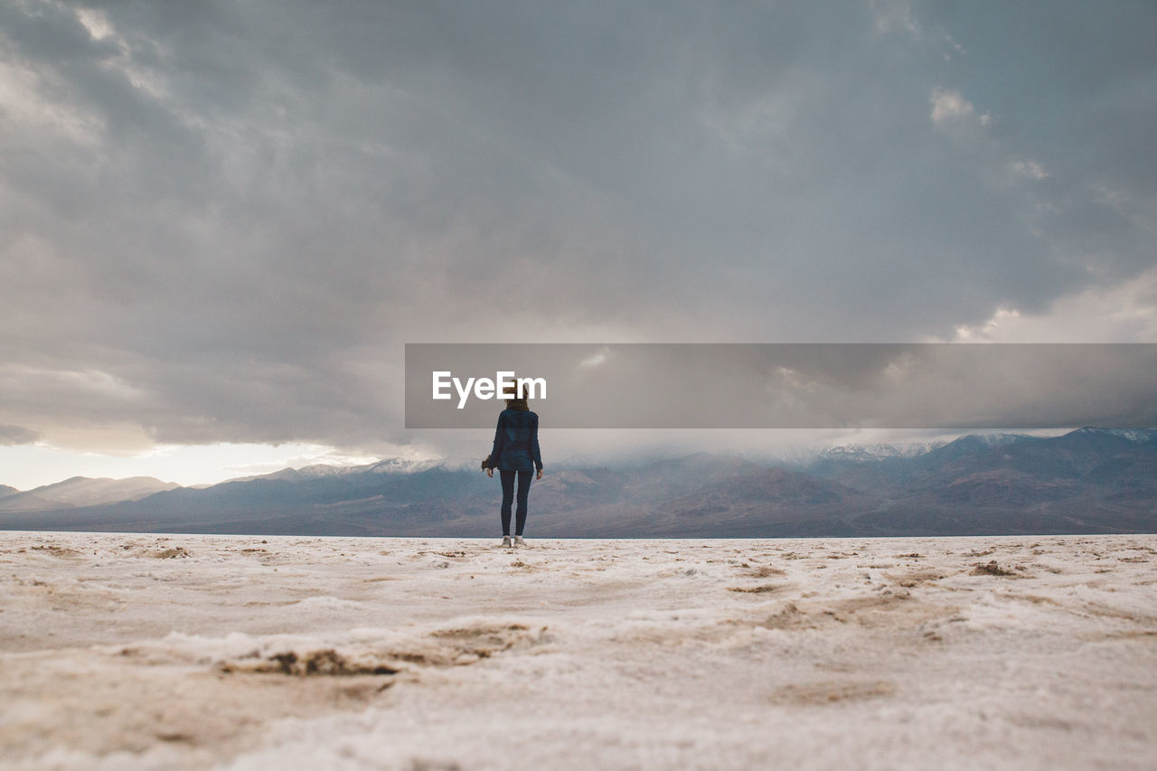 Full length of woman standing on desert against sky
