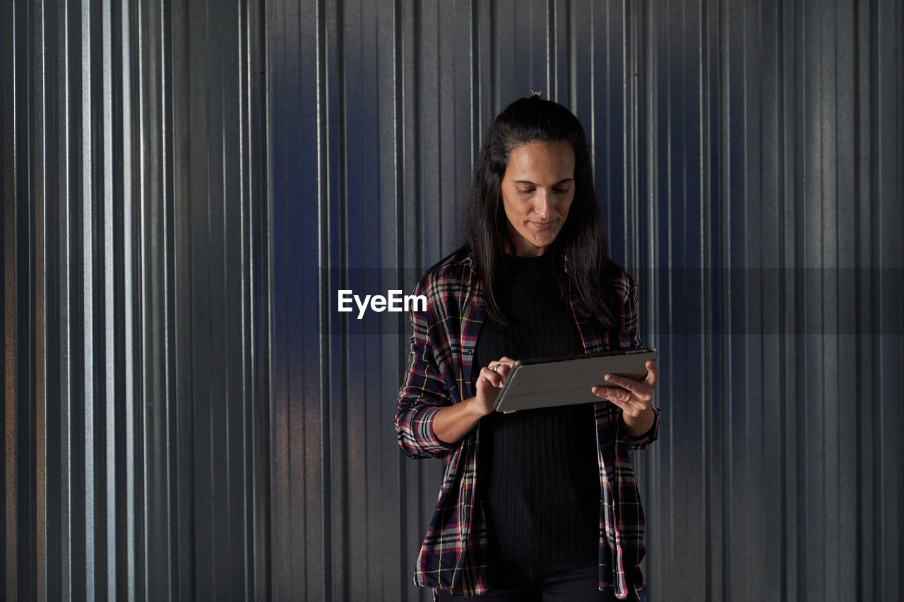 Woman standing at self storage door using tablet