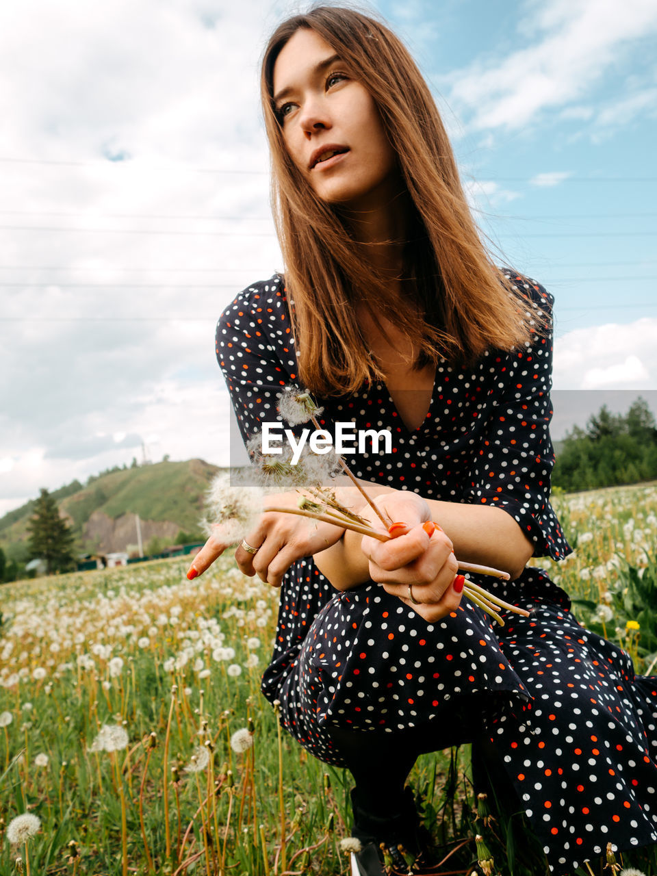 BEAUTIFUL YOUNG WOMAN HOLDING HANDS ON FIELD