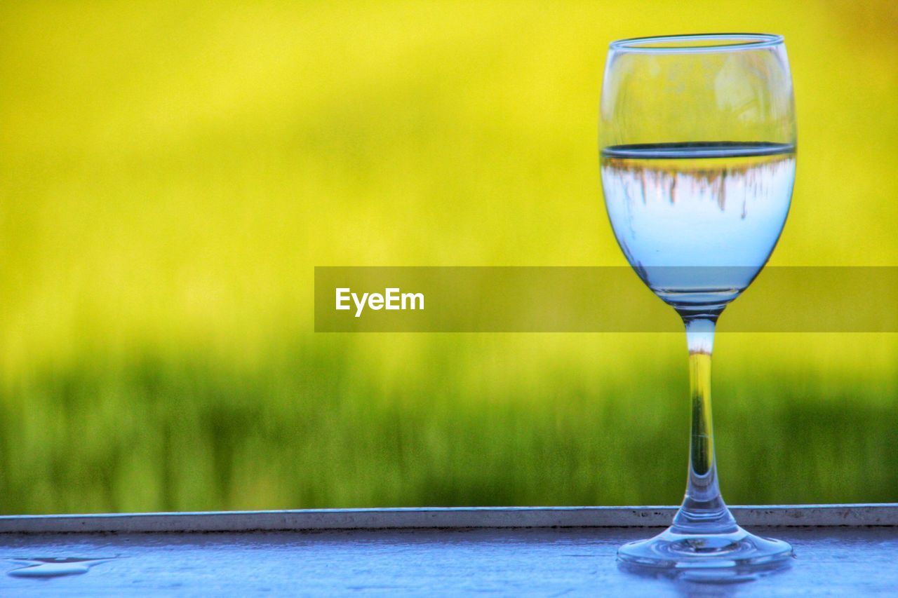 Close-up of wineglass against land on table