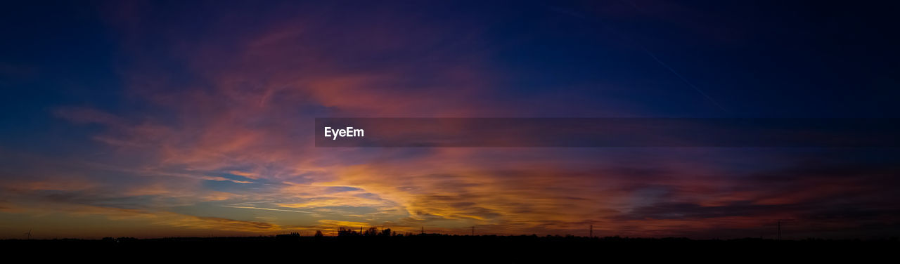 Scenic view of dramatic sky over silhouette landscape