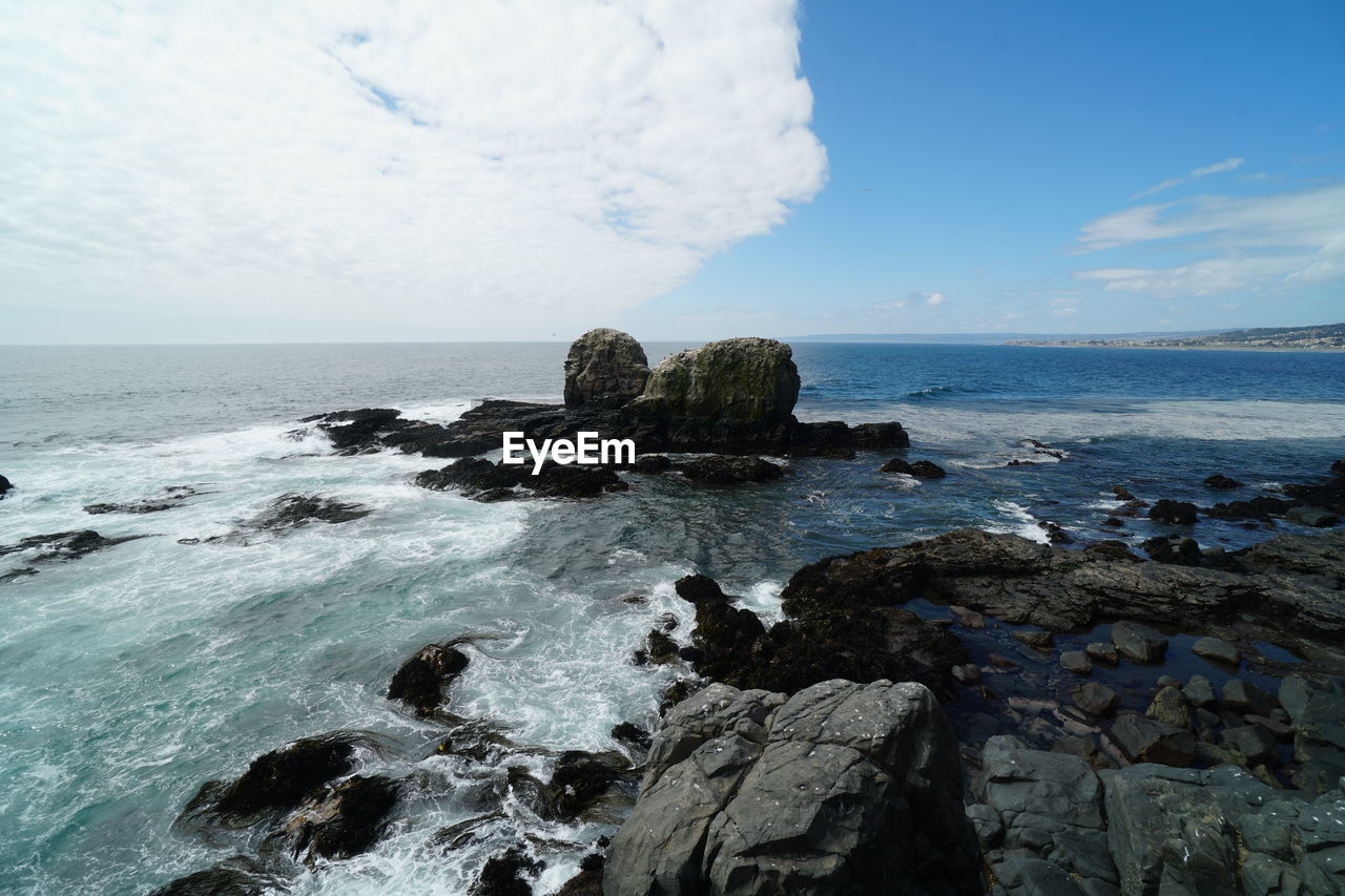 ROCKS ON SHORE AGAINST SKY