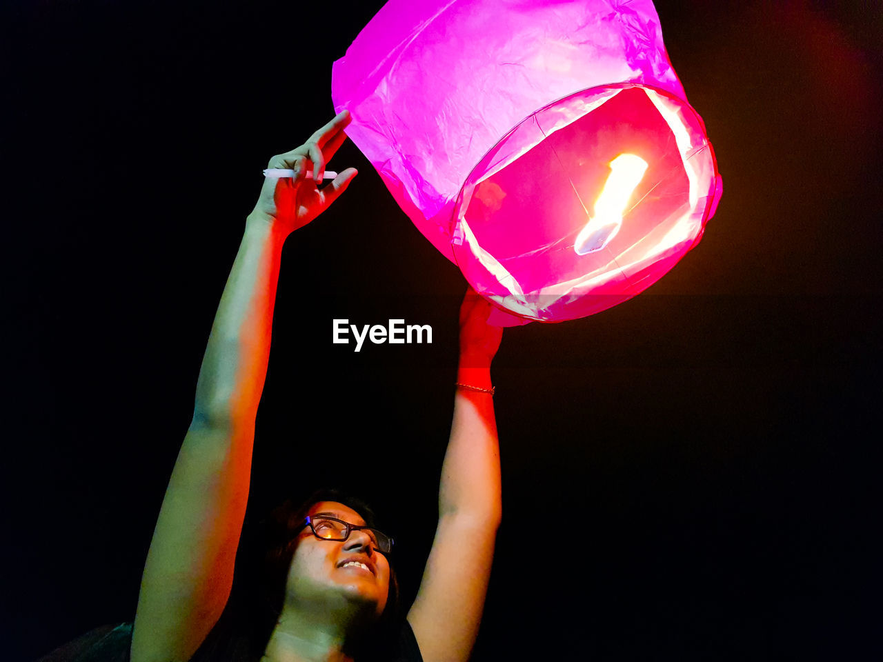 PORTRAIT OF YOUNG MAN WITH ARMS RAISED