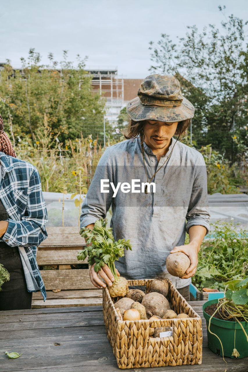 Young male environmentalist selling vegetables in farmer's market