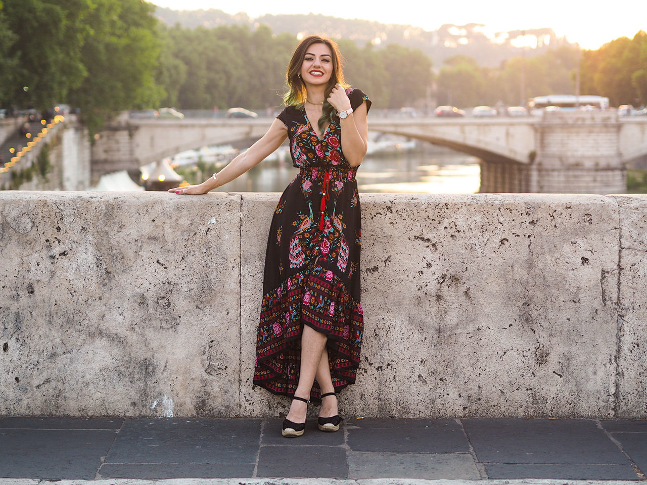 Portrait of beautiful woman leaning on railing while standing on footpath