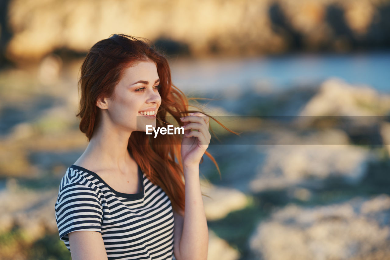 Smiling young woman looking away outdoors