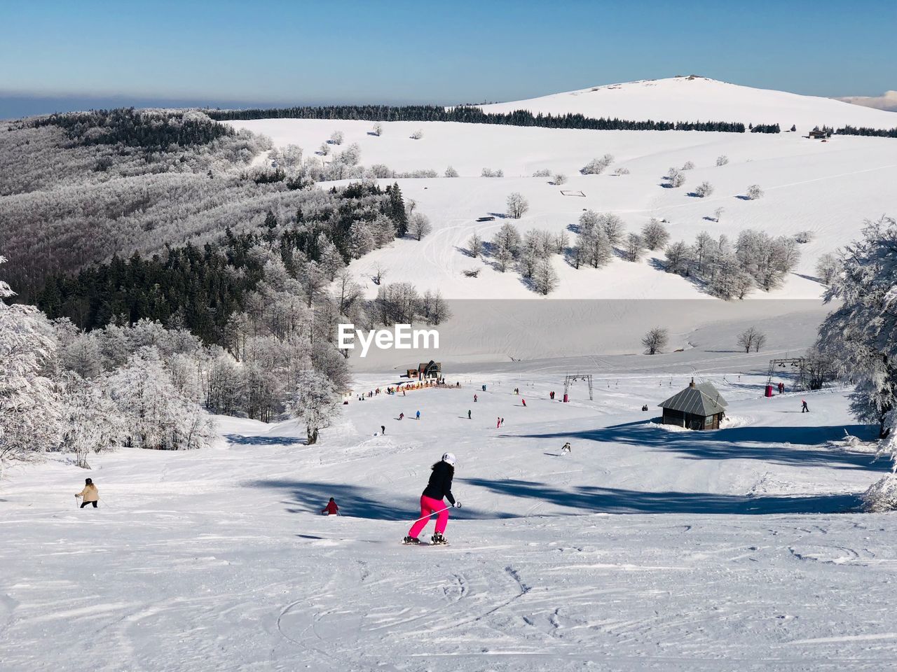 Woman skiing on snow covered mountain against sky