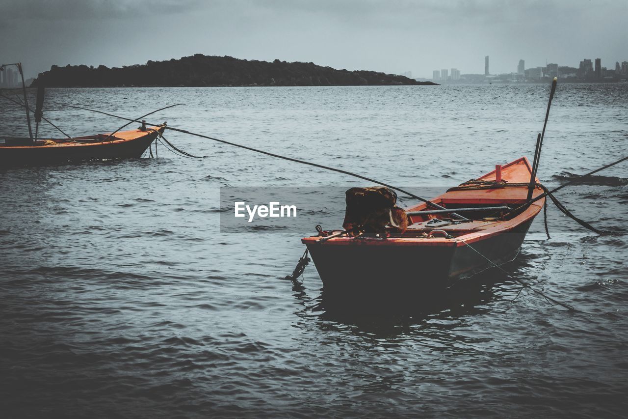 Boat moored in sea against sky