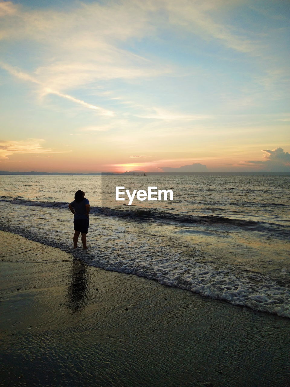 SILHOUETTE MAN STANDING AT BEACH DURING SUNSET