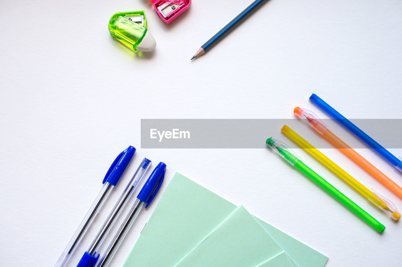 A set of stationery on a white background, pens of different colors.