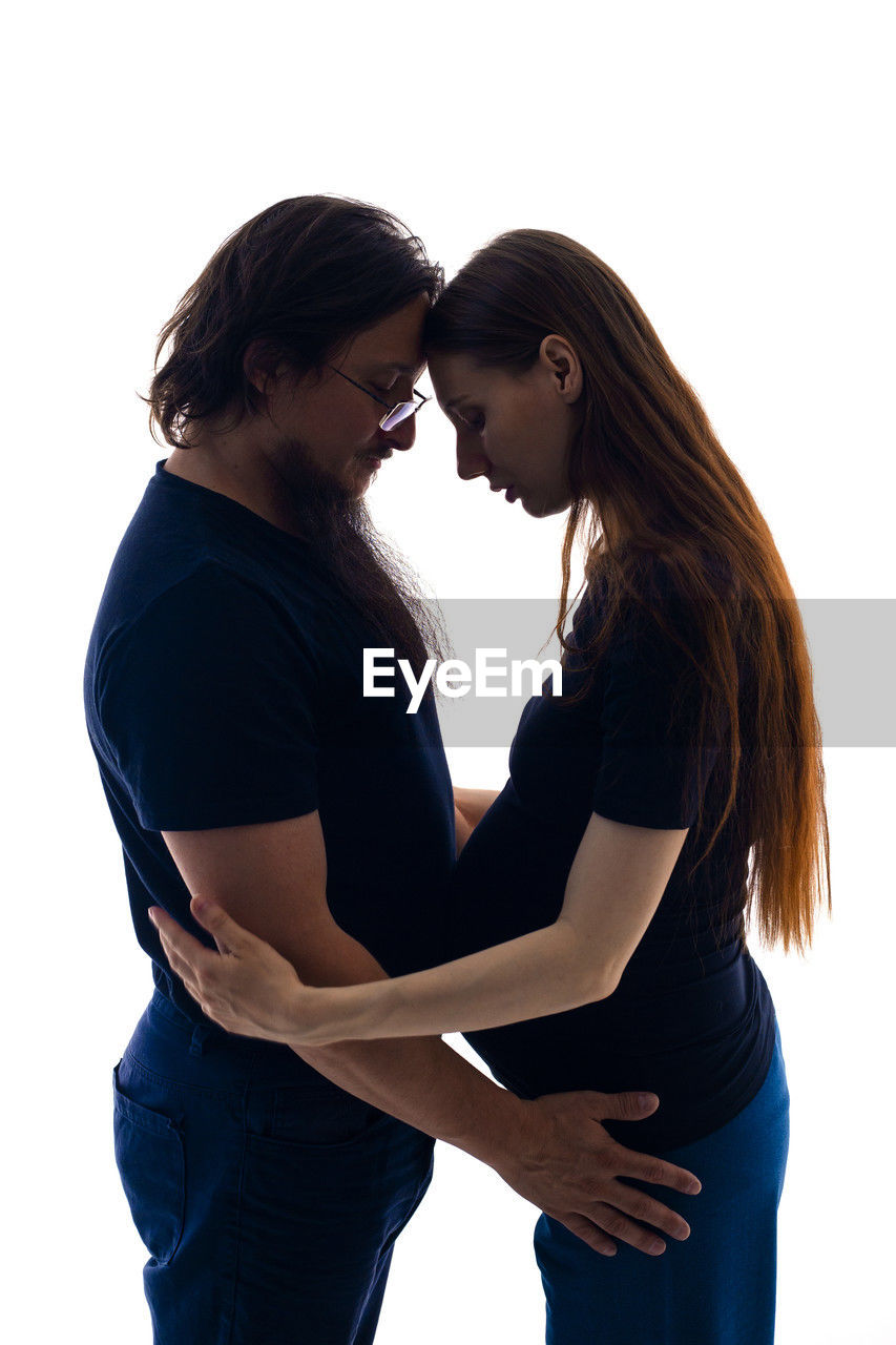 two people, women, adult, togetherness, positive emotion, emotion, love, young adult, female, white background, studio shot, bonding, affectionate, three quarter length, side view, embracing, indoors, casual clothing, cut out, hairstyle, long hair, standing, person, romance, happiness, care, brown hair, smiling, lifestyles, touching, child, men, friendship, clothing