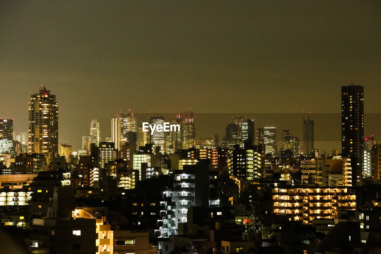 Illuminated cityscape against sky at night