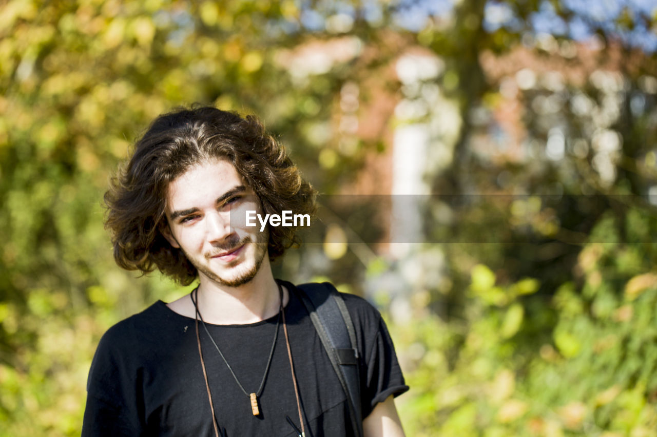 Close-up portrait of young man standing in forest