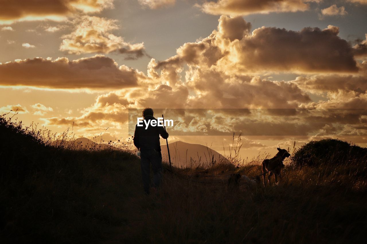 Men on field against sky during sunset