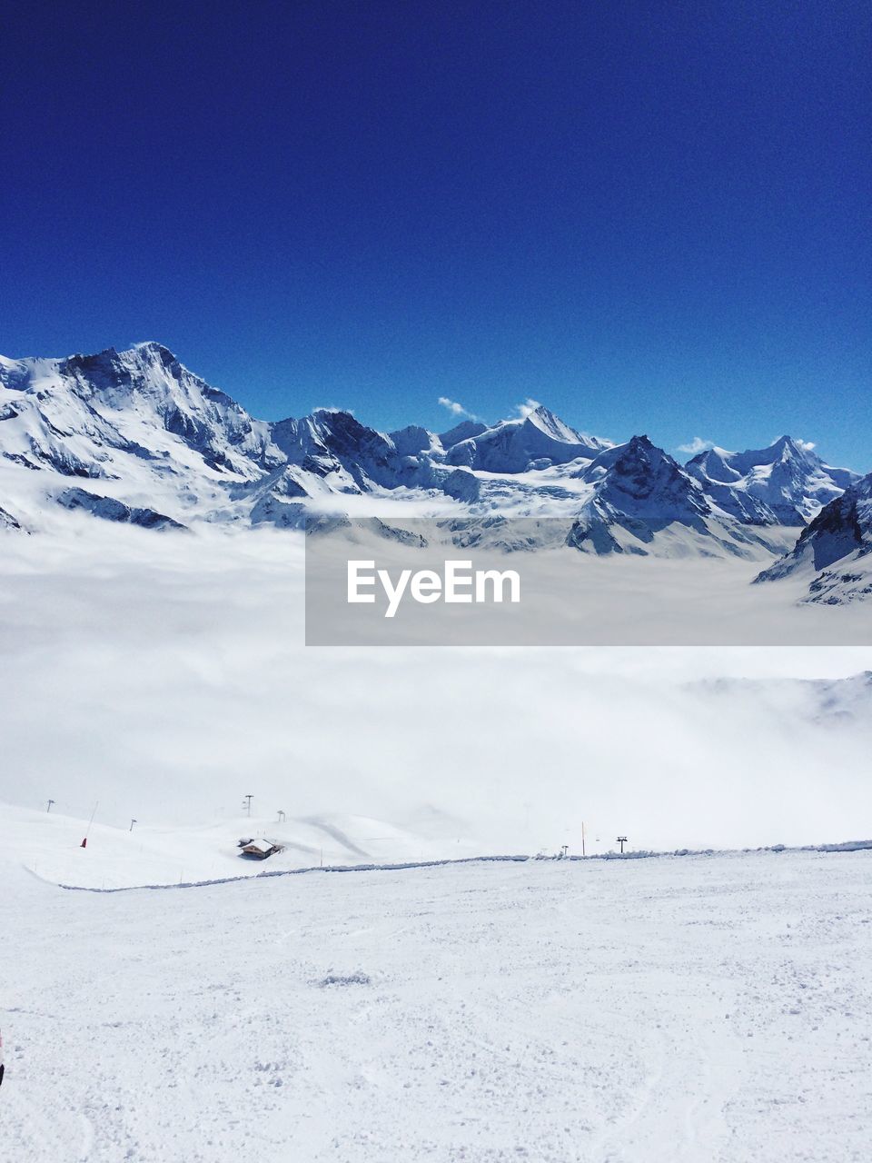 Scenic view of snowcapped mountain against blue sky