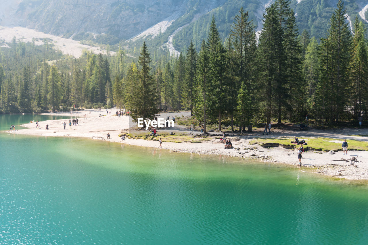 Braies, italy september 10, 2021 people on the braies lake admires the mountains during a sunny day