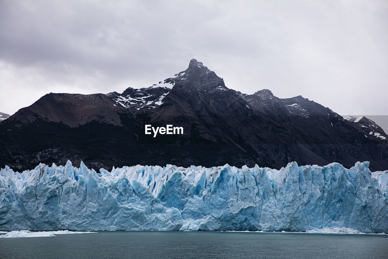 Scenic view of glacier against mountain and sky