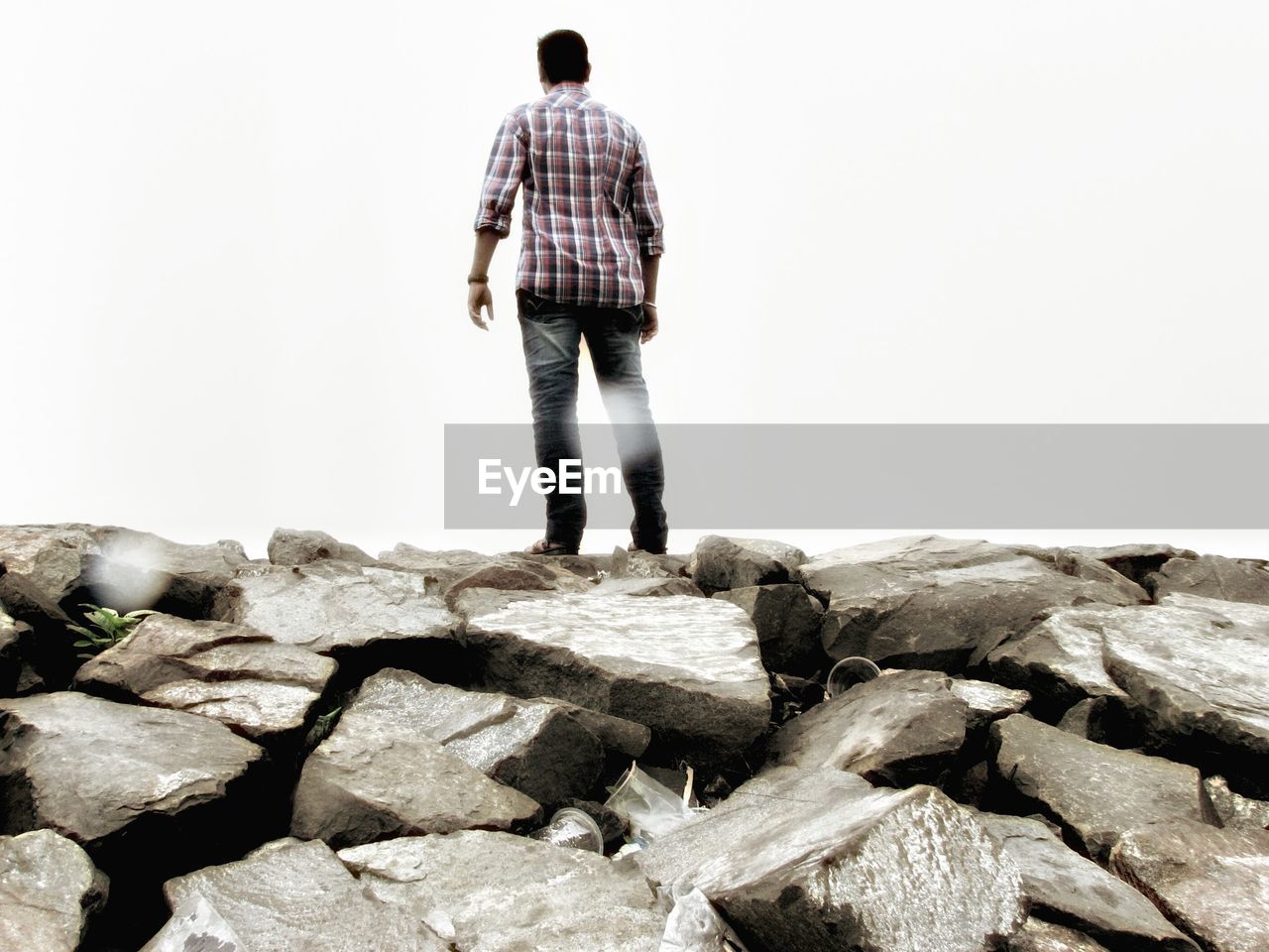 YOUNG WOMAN STANDING ON ROCK