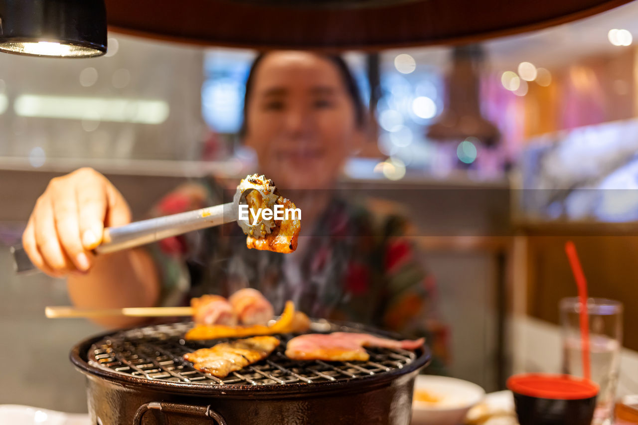 Woman preparing food on barbecue grill