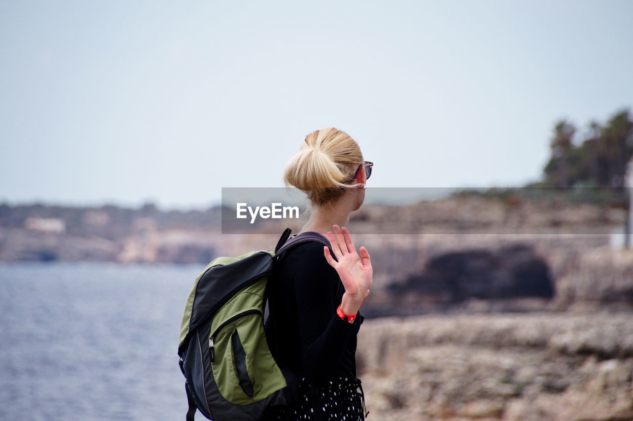 Side view of woman standing against clear sky